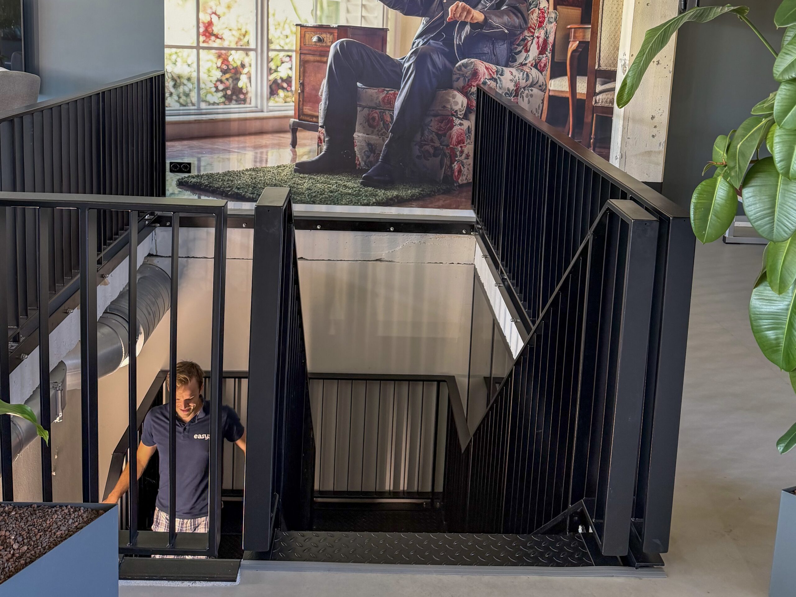 An Easysee employee descends the stairs during an inspection round of the office for the location of the new Experience Room.